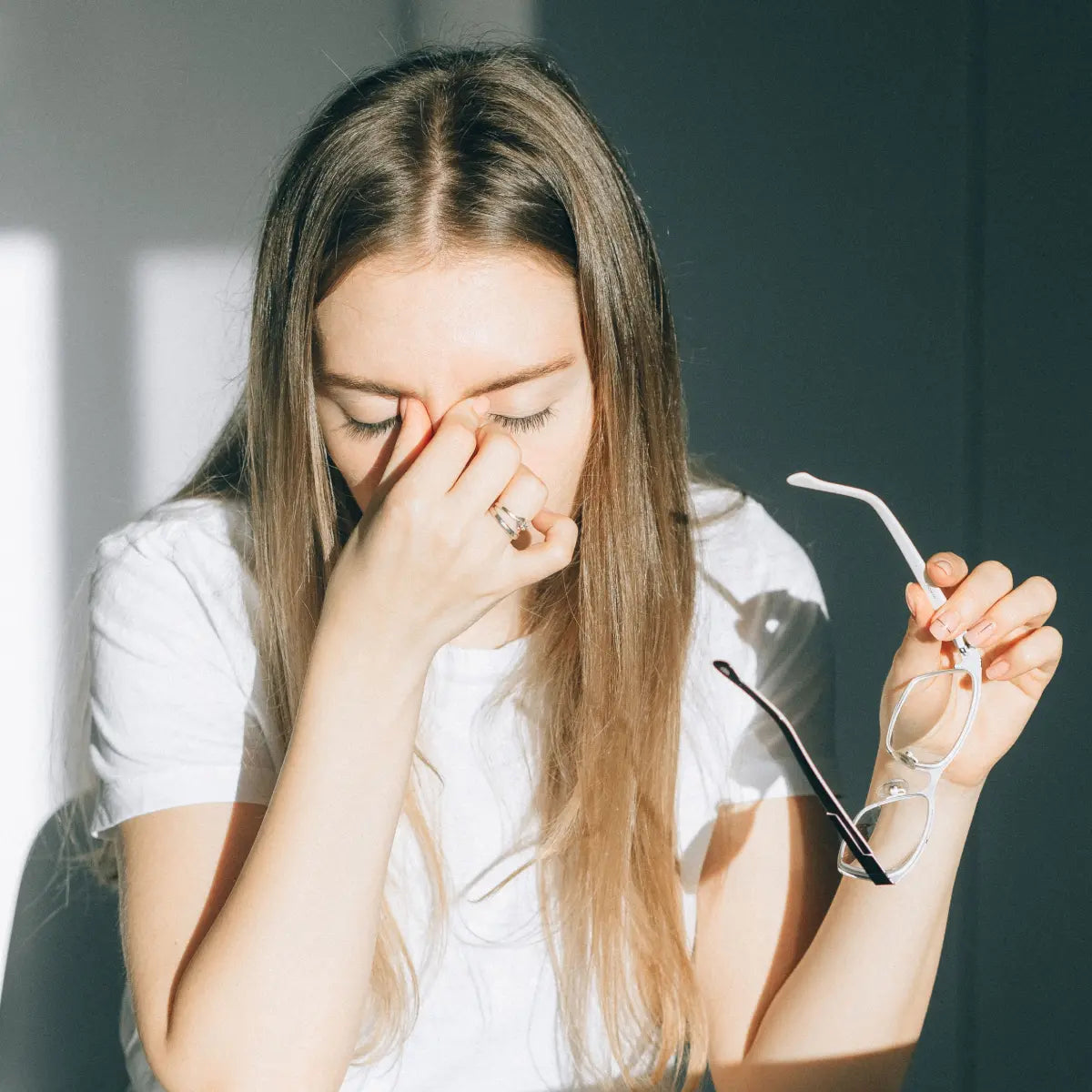 Woman experiencing cluster headache symptoms in bright light