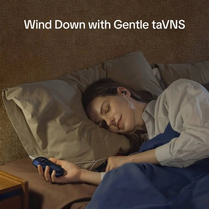 Woman relaxing in bed while using a gentle taVNS device before sleep.