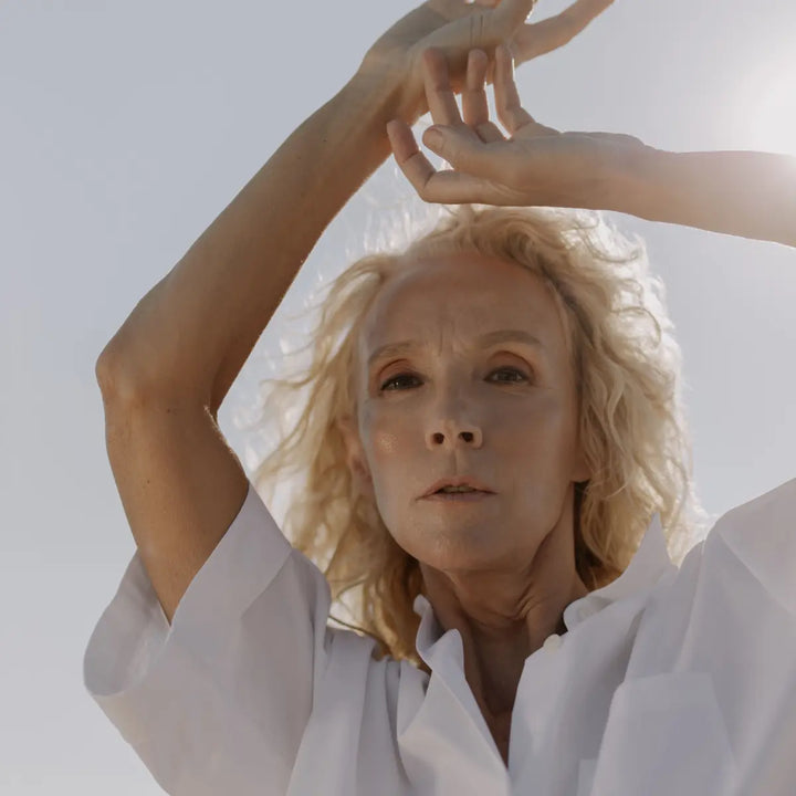 Older woman standing in natural light, representing healthy aging and long-term physical wellbeing