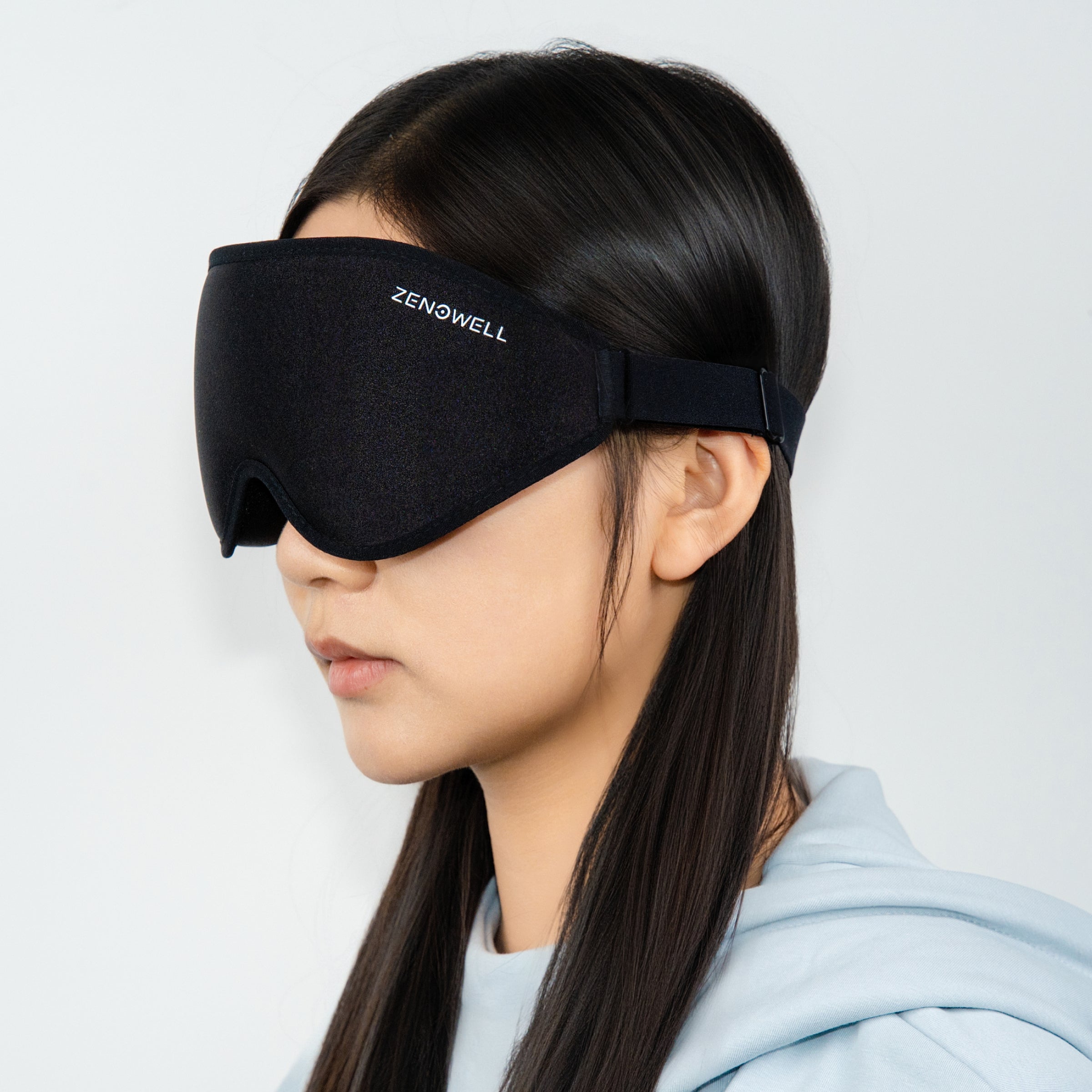 A person wearing a ZenoWell sleep mask, with the logo visible, the product from the side view.